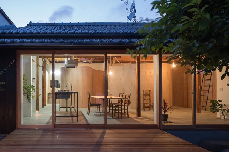 10 Contoh Fasad Rumah Panggung Minimalis Estetik yang Bikin Hunian Tampak Berkelas 4 Fasad rumah panggung dengan panel geser kayu, dikelilingi taman bergaya Jepang.