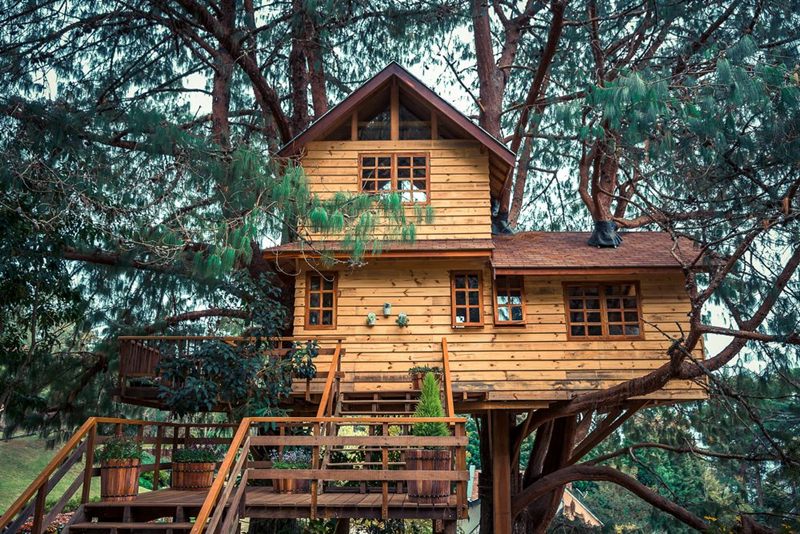 10 Contoh Fasad Rumah Panggung Minimalis Estetik yang Bikin Hunian Tampak Berkelas 11 Perspektif rumah kayu bertingkat dengan struktur seperti menggantung, dilengkapi tangga luar.